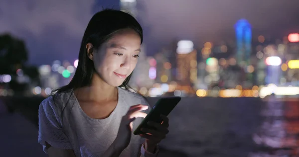 利用晚上时间在香港的智能手机的女人 — 图库照片