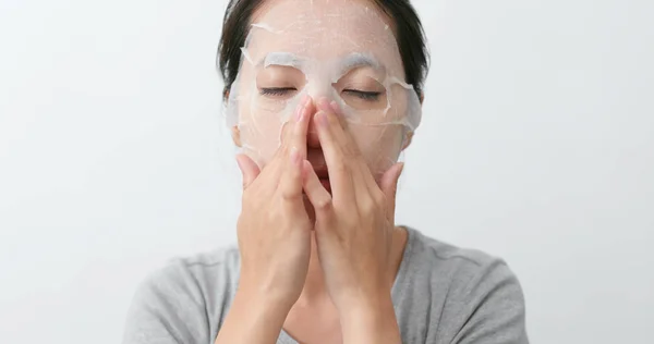女性の顔に紙マスクを適用します — ストック写真