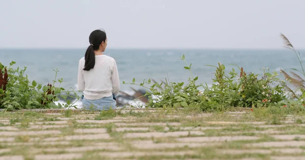 Back view of woman sit down and look at the sea