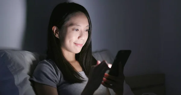 Woman using smartphone in the evening at home