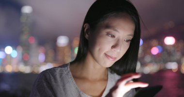 Geceleri cep telefonu kullanan kadın