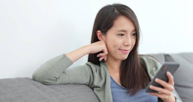 Evde cep telefonu kullanan bir kadın