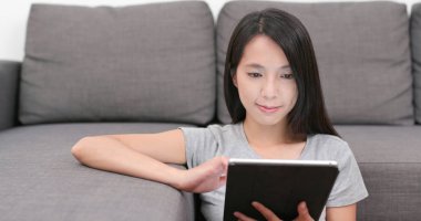 evde tablet bilgisayar kullanan kadın