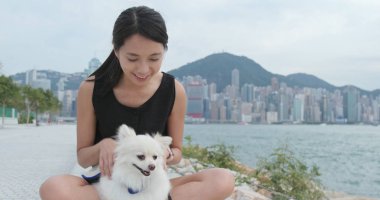 Kadın ile beyaz pomeranian köpek vasıl açık oyun