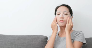 Kadının yüzündeki kağıt maske uygulamak