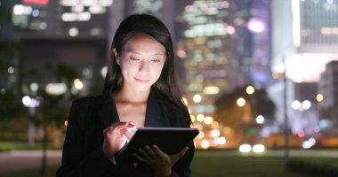 Asya geceleri tablet bilgisayar kullanarak iş kadını