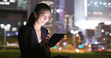 Asya geceleri tablet bilgisayar kullanarak iş kadını