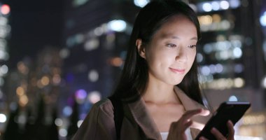 cep telefonuyla şehirde gece kadın