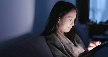 Akşamları evde tablet bilgisayar kullanan kadın