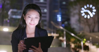 Genç işkadını geceleri tablet bilgisayar kullanarak