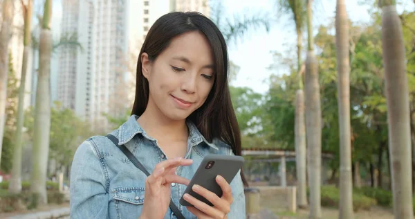 Kadın smartphone vasıl park açık üzerinde okuma