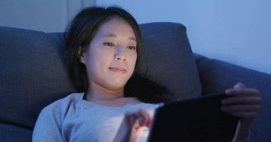 Geceleri tablet bilgisayar kullanan kadın