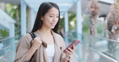 Şehirde akıllı telefon kullanan bir kadın.