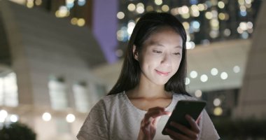 Kadın geceleri tren istasyonunda cep telefonu mobil app kullanma