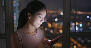 Cep telefonu evde akşamları kullanan kadın