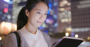 Tablet bilgisayar geceleri açık istasyonda kullanarak iş kadını