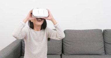 Sanal gerçeklik aygıtıyla evde izlerken kadın