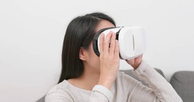 Evde VR aygıtla arayan kadın