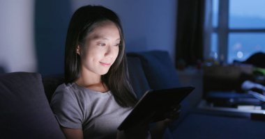 Akşamları evde tablet bilgisayarda izlerken kadın