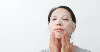 Kadın uygulamak kağıt maske ve yüzünde Masaj