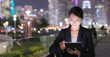 Genç işkadını geceleri tablet bilgisayar kullanarak