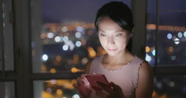 Evde cep telefonu kullanan bir kadın