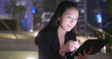 Geceleri tablet bilgisayar kullanarak iş kadını