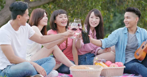 Arkadaşlar birlikte parkta piknik gidin ve yiyecek ve içecek keyfini çıkarın