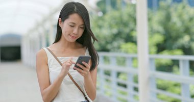 Şehirde akıllı telefon kullanan bir kadın