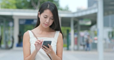 Genç kadın cellphone şehir içinde App kullanma