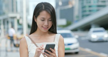 Asyalı kadın cellphone şehir içinde App kullanma