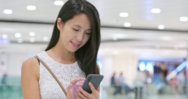 Alışveriş Merkezi içinde cep telefonu kullanan kadın