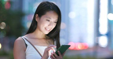 cep telefonuyla şehirde gece kadın