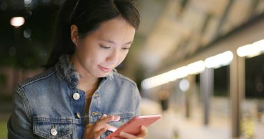 Gece akıllı telefon kullanan bir kadın.