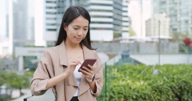 Akıllı telefon kullanan genç bir kadın.