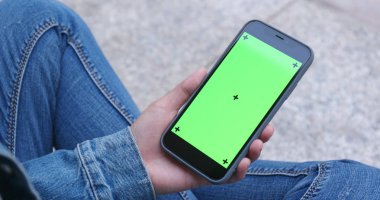 Cep telefonu ile yeşil ekran kullanan kadın 