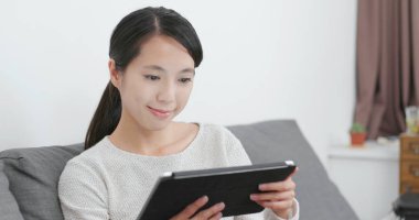 Kadın evde tablet bilgisayarda okuma