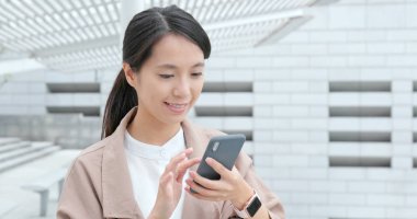 Akıllı telefon kullanan genç bir kadın.