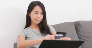 Dizüstü bilgisayar ve kredi kartı kullanarak alışveriş kadın