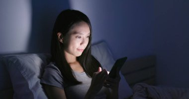 Cep telefonu evde akşamları kullanan kadın