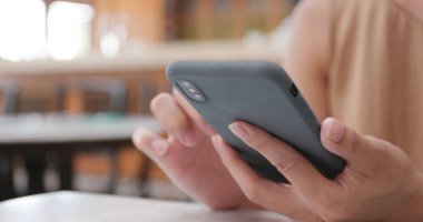 Cep telefonu kafede kullanan kadın