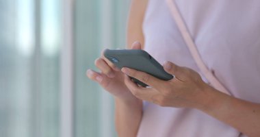 Alışveriş merkezinde cep telefonu kullanan bir kadın.