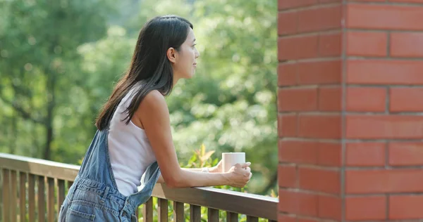 妇女在阳台享用她的咖啡 — 图库照片