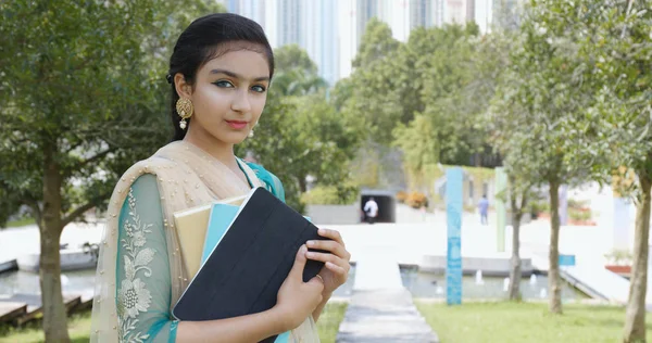 屋外で本やタブレットを保持しているパキスタン学生の女の子 — ストック写真