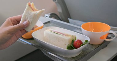 Uçakta kadın yeme sandviç