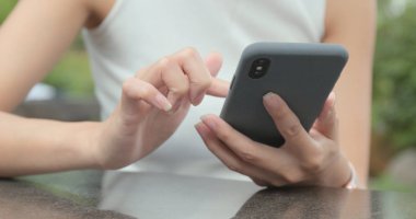 Açık café'de akıllı telefon kullanan kadın