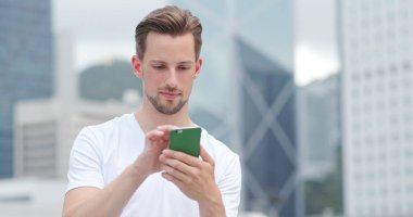 Beyaz genç adam cep telefonu kısa mesaj için kullanma