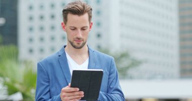 Açık, dijital tablet üzerinde çalışan iş adamı