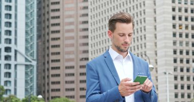 Cep telefonunuzun ve Hong Kong şehrinde beyaz iş adamı