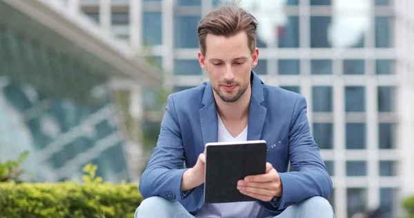 Businessman work on tablet computer in city